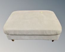 A rectangular footstool in green upholstery.