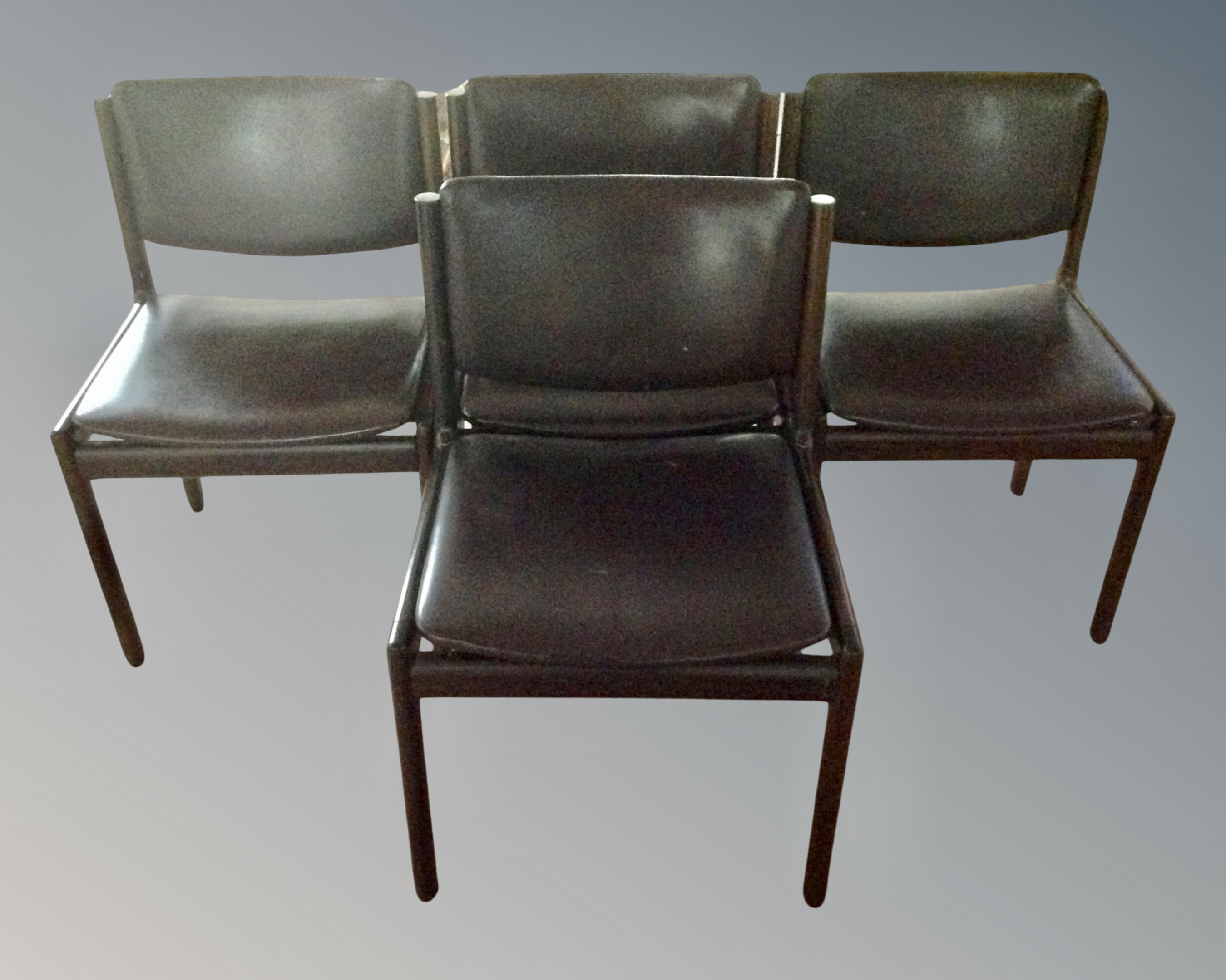 A set of four late 20th century continental dining chairs in brown vinyl upholstery.