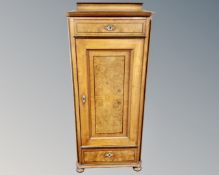 A 19th century continental burr walnut and ebonized single door hall cabinet.