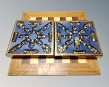 A wooden chess board together with a box of cast brass Roman style chess pieces