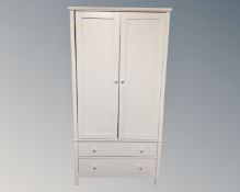 A John Lewis double door wardrobe fitted with two drawers beneath.