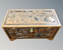 A heavily carved Oriental camphor wood blanket chest.