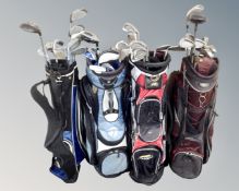 Four golf bags containing assorted irons and driver.