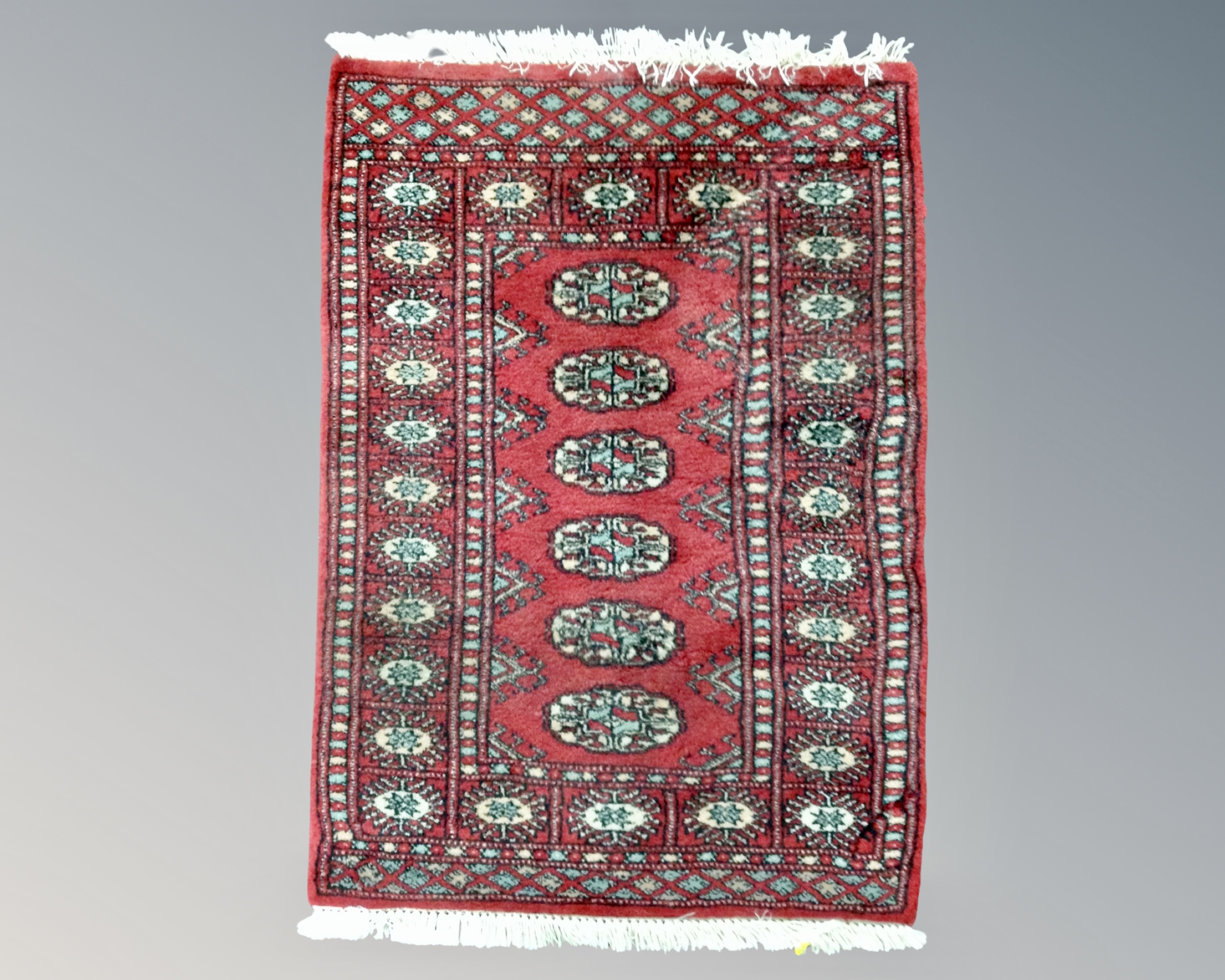 An Afgan Bokhara rug on red ground 98 cm x 66 cm