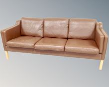 A late 20th century Scandinavian three seater settee in brown leather,