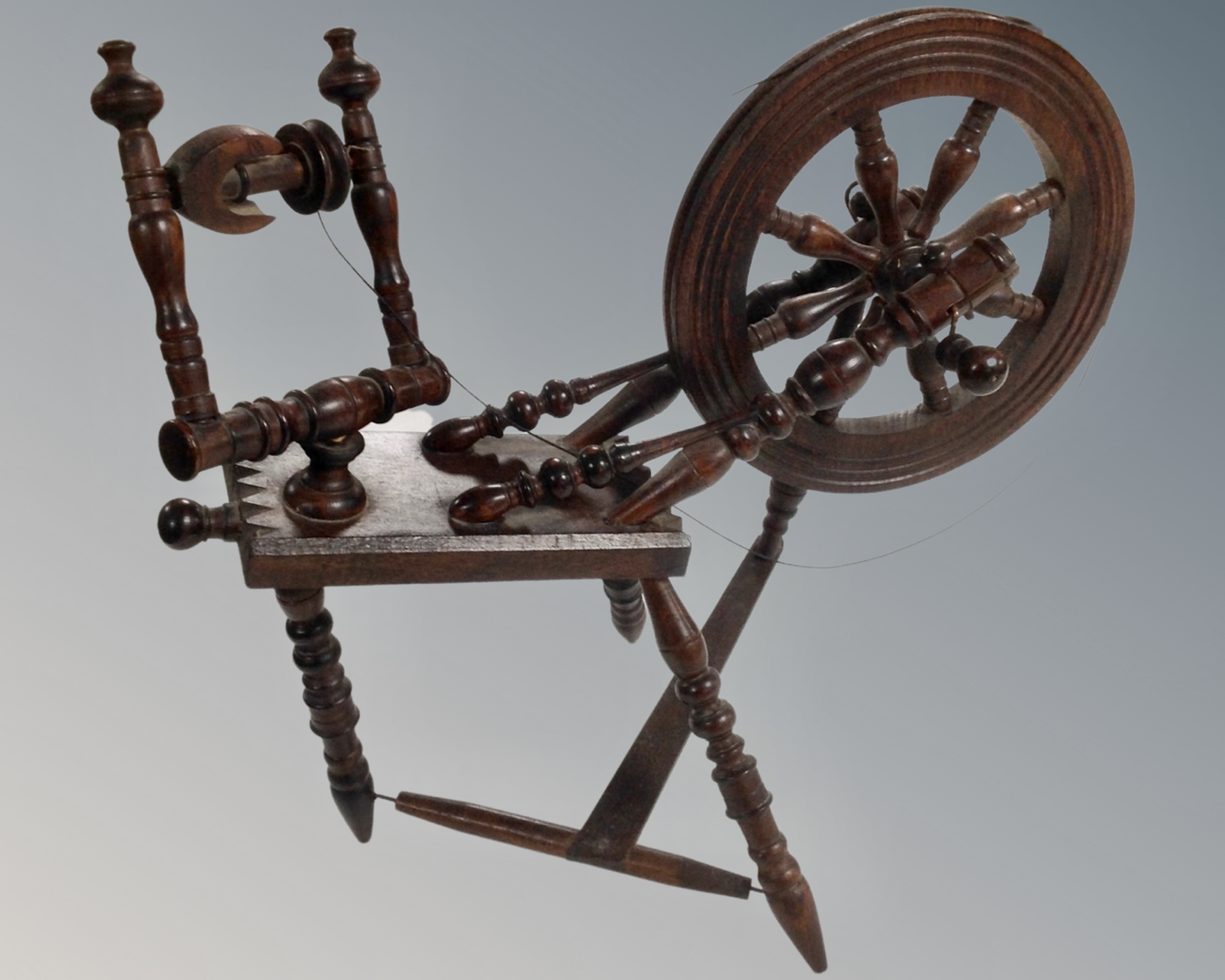 A miniature antique spinning wheel.