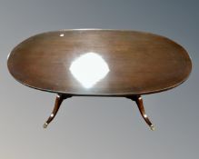 An oval inlaid mahogany glass topped coffee with understretcher on brass capped feet (length 115cm)
