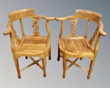A pair of Chinese style carved and stained wooden corner armchairs.