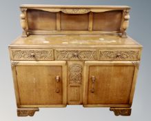 A 1930's carved oak buffet back sideboard (width 137cm) CONDITION REPORT: Watermarks