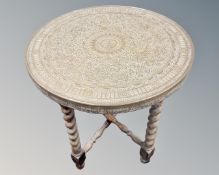An Eastern brass topped circular occasional table.