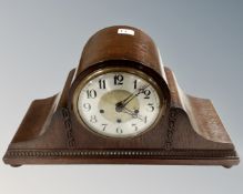 An Art Deco oak cased mantel clock with silvered dial, width 49 cm.