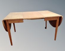 A 20th century teak extending dining table.