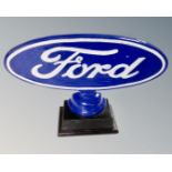A reproduction painted metal Ford sign on stand