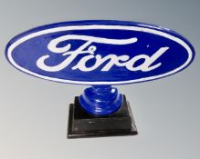 A reproduction painted metal Ford sign on stand