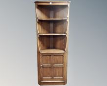 An Ercol stained elm corner cabinet.