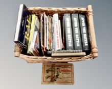 A basket containing 'After the Battle' magazines in binders, further books relating to war,