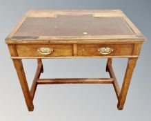 A late 19th century oak two drawer writing desk with leather inset surface.