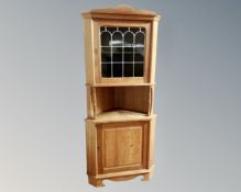 A continental blond oak and stained glass corner cabinet.