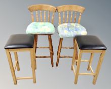 A pair of pine bar stools together with a further pair of black vinyl stools.