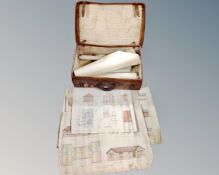 A vintage leather luggage case containing rolled architectural plans