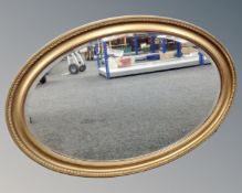 A large oval gilt framed bevel edged mirror.
