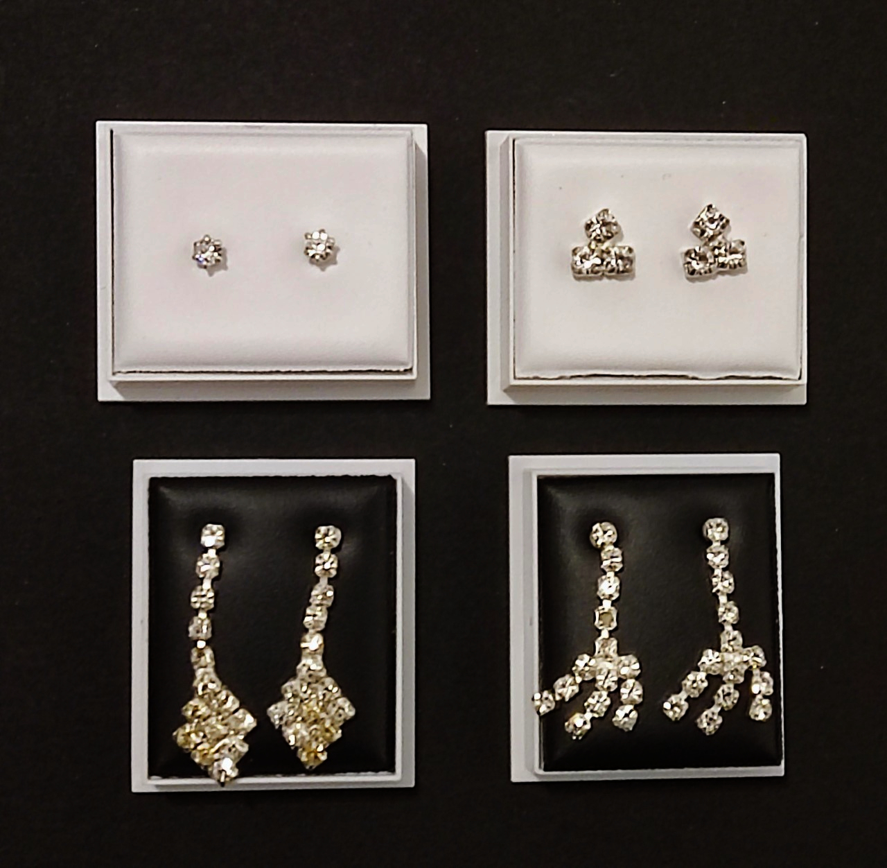Two pairs of diamante drop earrings and stud earrings.