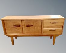 A good quality 1960's teak low sideboard, fitted with two drawers on raised legs,