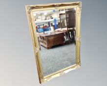 A bevel edged mirror in swept gilt frame.