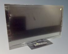 A Panasonic Viera 37" LCD TV with remote together with a wooden TV stand.