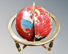 A gemstone globe on brass stand.