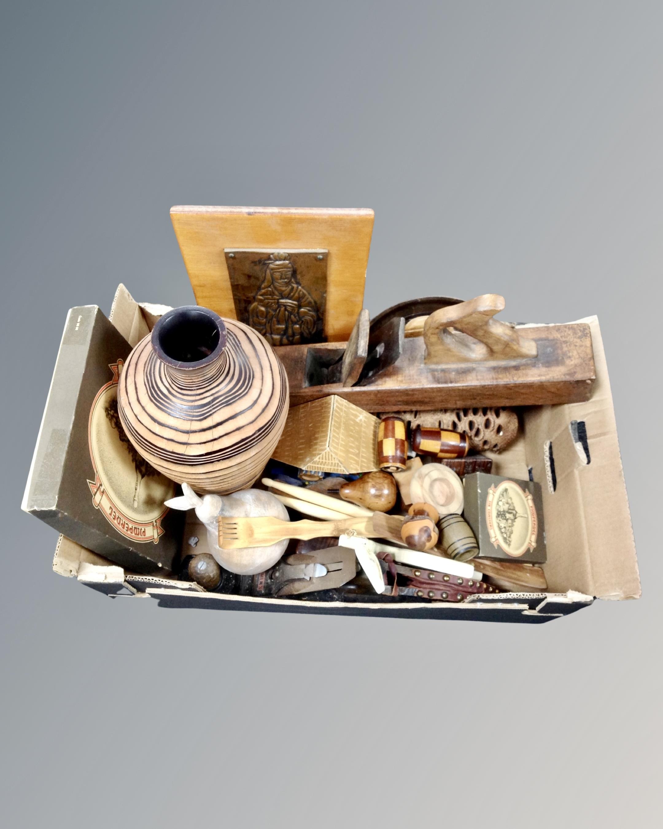 A box containing treen, woodworking plane, a set of boxed place mats, miniature pair of bellows.