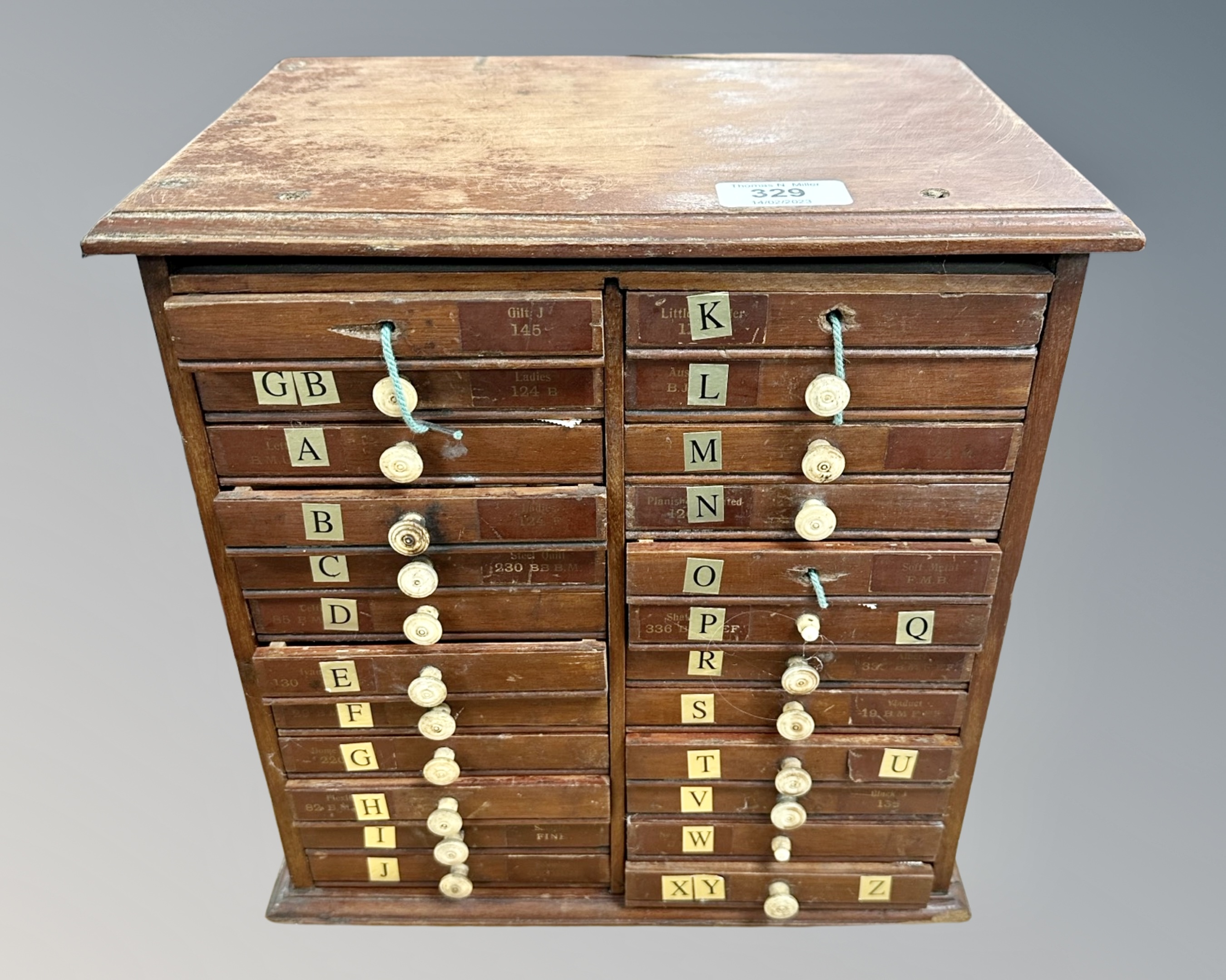 An early 20th century sample cabinet, fitted with twenty-four drawers, containing stamps,