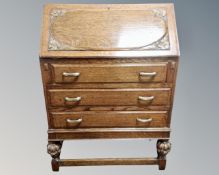 A 1930's carved oak writing bureau with fitted interior