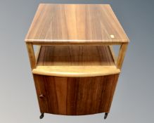 A mid century occasional table fitted with a record cupboard below, in walnut finish.