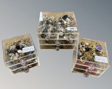 Three small nests of perspex drawers containing a collection of costume earrings,
