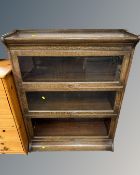 A three tier oak stacking bookcase. CONDITION REPORT: One glass panel missing.