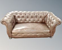 A late Victorian two-seater Chesterfield club settee in buttoned brown leather