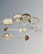 Four silver napkin rings, two enamelled spoons and a pair of 19th century silver sugar nips.
