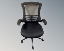 An adjustable office armchair in black mesh fabric