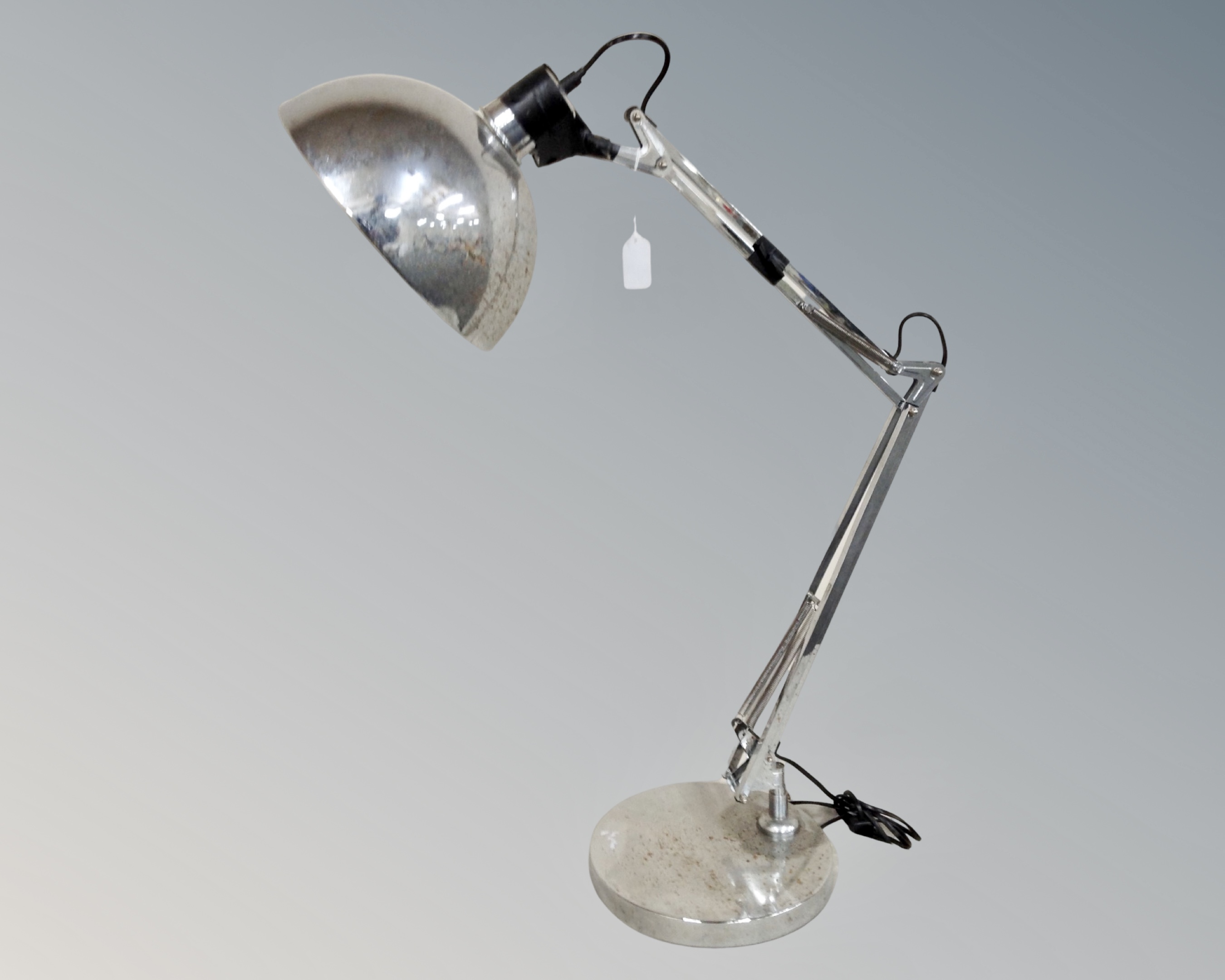 An oversized angle-poise lamp in a chrome finish