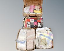 A wicker basket and three boxes containing a large quantity of assorted linen