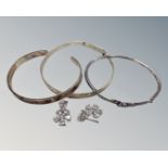Three silver bracelets together with a pair of silver diamonte earrings.