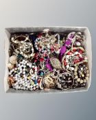 A box containing a large quantity of costume jewellery, bead necklaces, bangles etc.