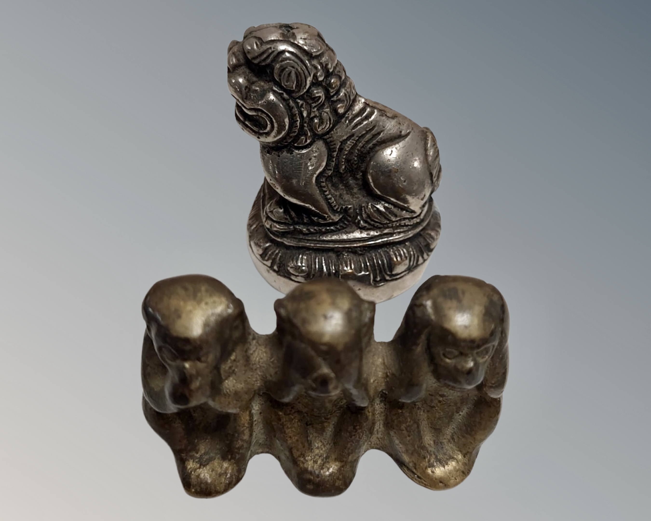 A brass figure of three monkeys and a silver plated lion.