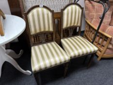 A pair of occasional chairs on reeded legs, upholstered in a green and cream striped fabric.