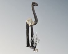A wooden floor standing ornament depicting a camel together with a decorative metal ten-way tea