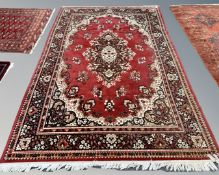 A Persian style carpet on red ground,