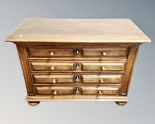A four drawer block chest on bun feet in an antique finish