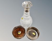 A lead crystal decanter with silver collar together with two silver plated bottle coasters and two