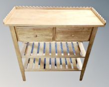 A contemporary pine hall table fitted with two drawers and shelves with gallery